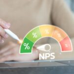 Net promoter score (NPS) dashboard concept for customer satisfaction and business analytics. Hand using a stylus with a hologram gauge for survey evaluation and KPI data.